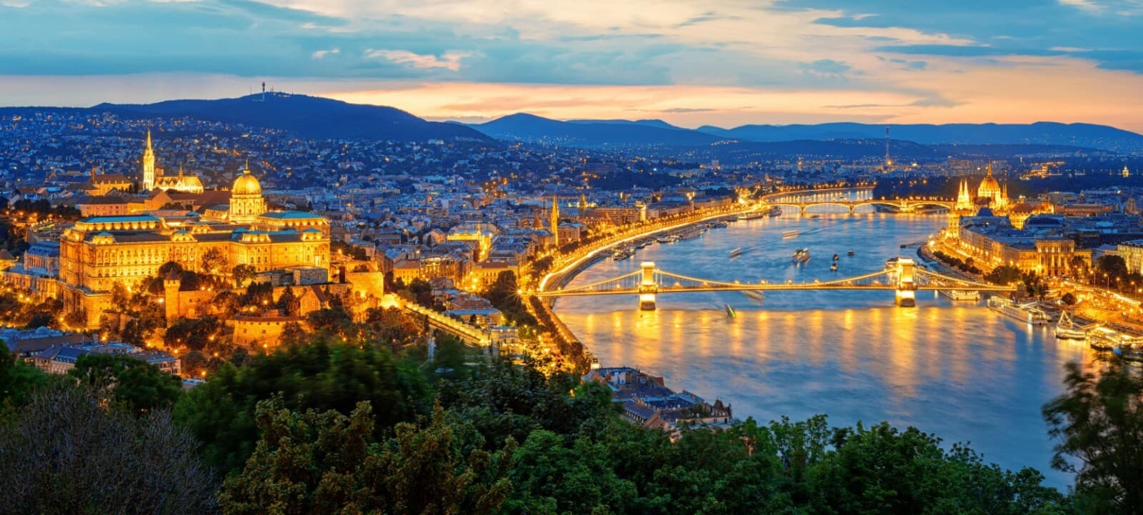 Night panorama of Budapest: the floodlit castle, the Chain Bridge over the Danube and the Parliament in the distance