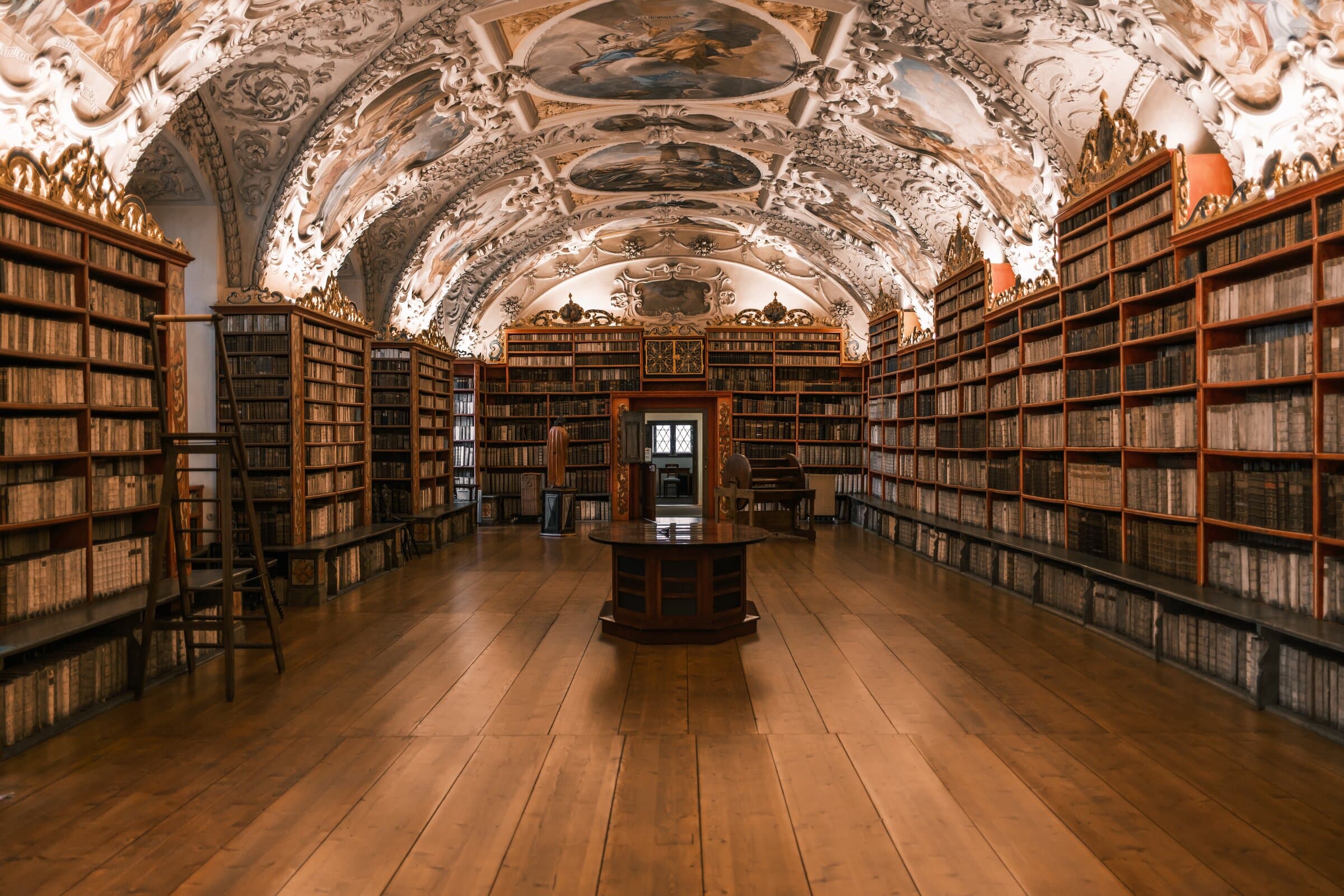 Empty baroque library hall with a stucco and fresco ceiling above wooden bookcases